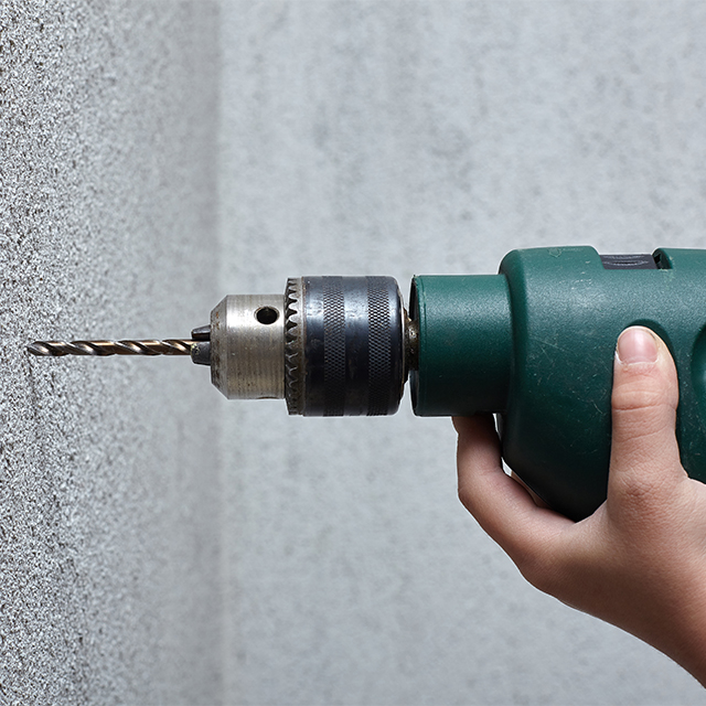 Picture of a drill drilling into a wall