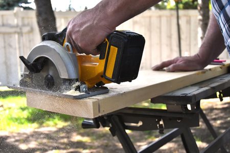 Picture of a man sawing with a circular saw